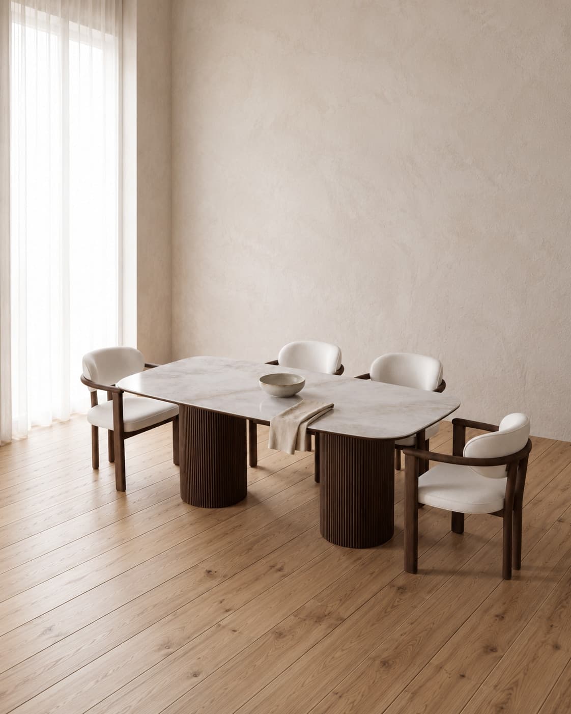 Ceramic dining table with fluted walnut pedestals and four upholstered chairs in a warm, sunlit room